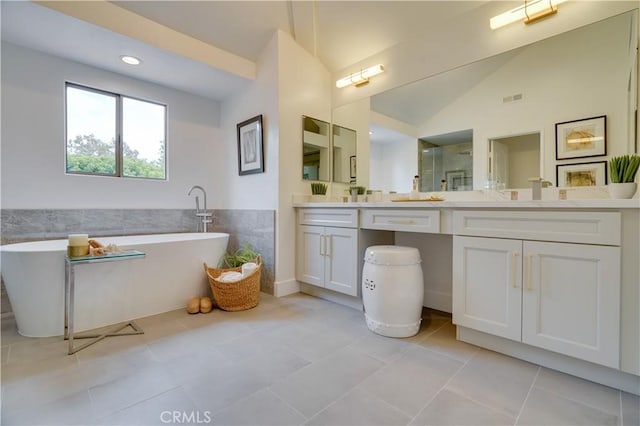 full bath featuring a shower stall, vaulted ceiling, vanity, a freestanding bath, and visible vents