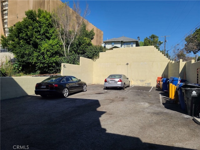 uncovered parking lot featuring fence