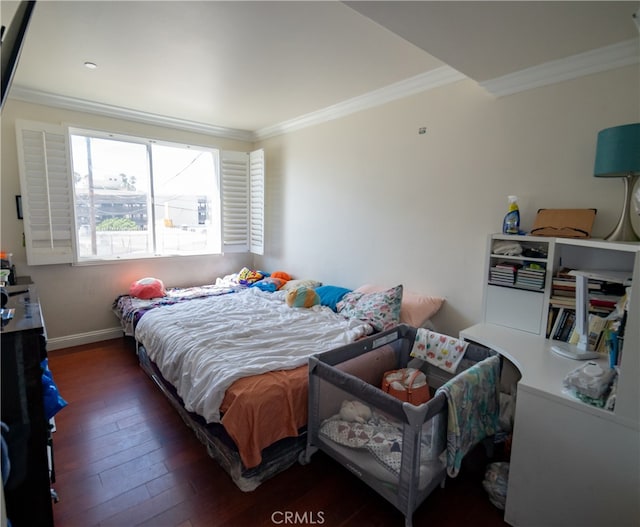 bedroom with ornamental molding and dark hardwood / wood-style floors