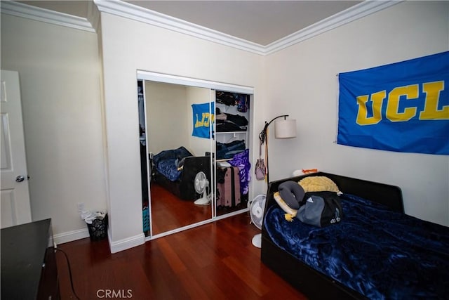bedroom featuring a closet, ornamental molding, baseboards, and wood finished floors