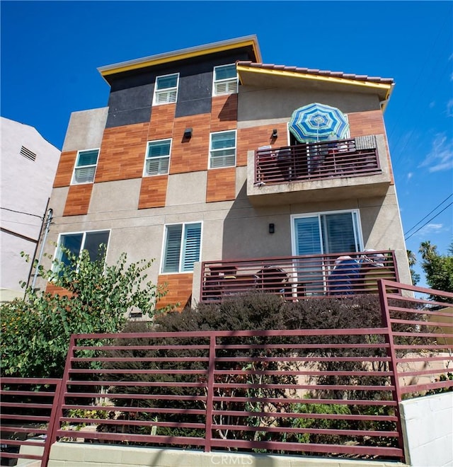 view of property featuring stucco siding and a balcony