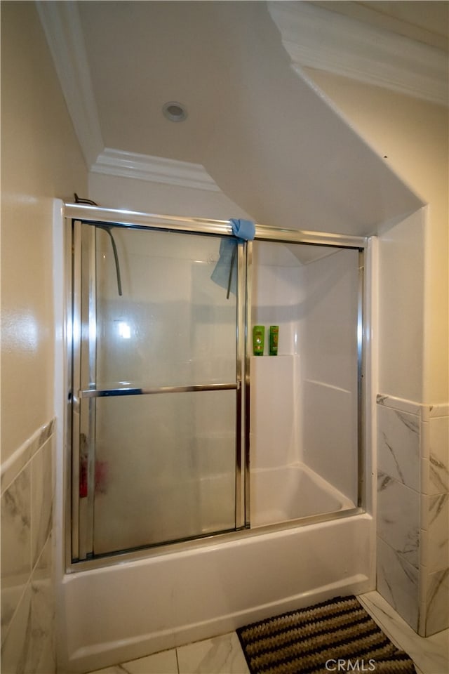 bathroom with ornamental molding and bath / shower combo with glass door