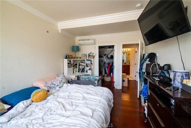 bedroom with crown molding, a closet, an AC wall unit, and wood finished floors