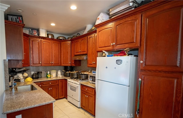 kitchen featuring decorative backsplash, sink, light tile patterned floors, light stone counters, and white appliances