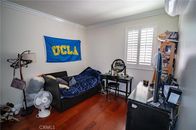 bedroom with ornamental molding and wood finished floors