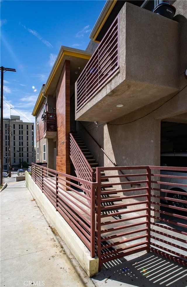 view of side of home with stucco siding and a balcony