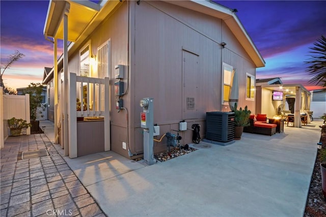 property exterior at dusk featuring a patio area