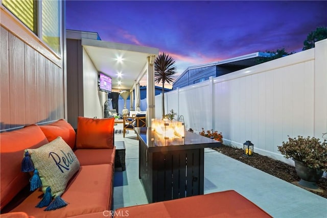 patio terrace at dusk featuring an outdoor living space with a fire pit