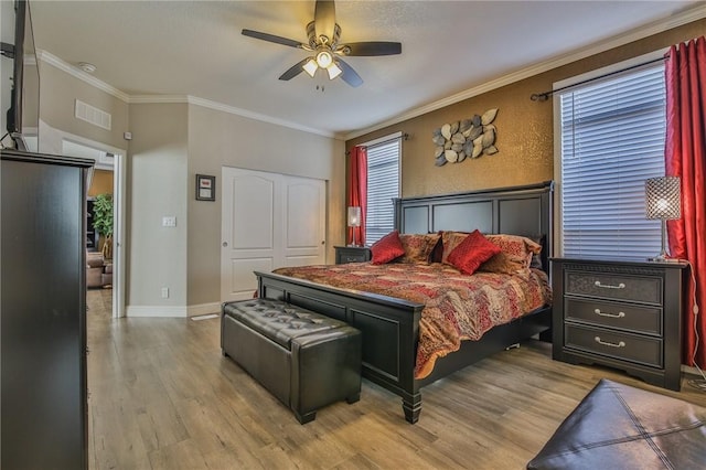 bedroom with ceiling fan, ornamental molding, a closet, and hardwood / wood-style flooring