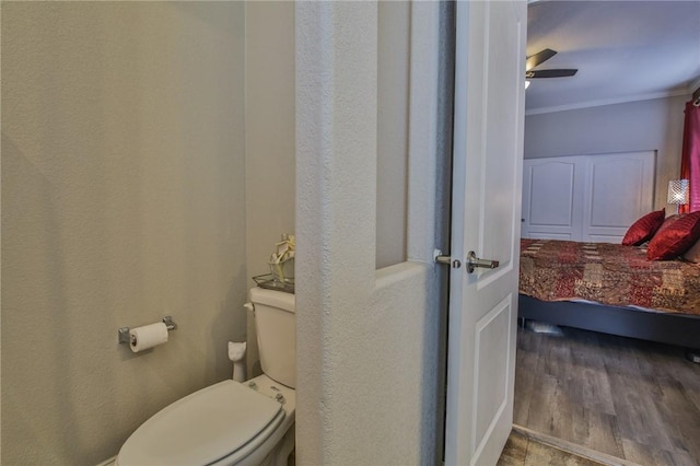 bathroom featuring toilet, ceiling fan, crown molding, and hardwood / wood-style flooring