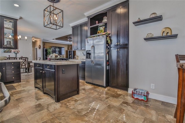 kitchen with a notable chandelier, stainless steel fridge, dark brown cabinetry, and decorative light fixtures