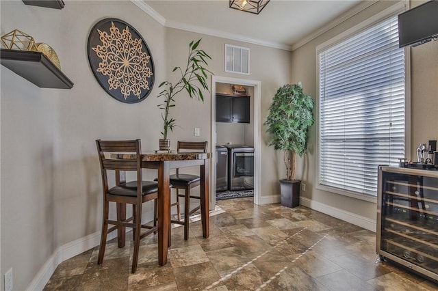 dining room with beverage cooler and ornamental molding