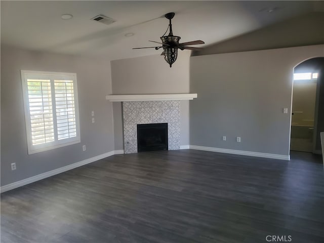 unfurnished living room with ceiling fan, dark wood-type flooring, vaulted ceiling, and a fireplace