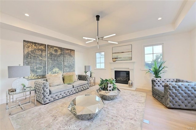 20487 Gartel Dr, Walnut, CA 91789 - living area featuring a tray ceiling, wood finished floors, a glass covered fireplace, recessed lighting, and baseboards