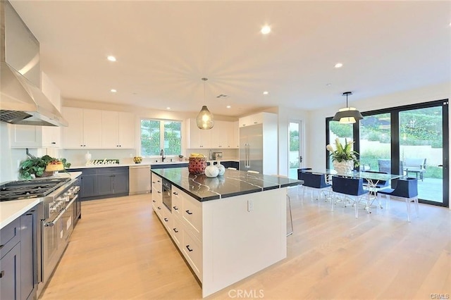 20487 Gartel Dr, Walnut, CA 91789 - kitchen with wall chimney range hood, appliances with stainless steel finishes, light wood finished floors, plenty of natural light, and recessed lighting