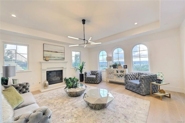20487 Gartel Dr, Walnut, CA 91789 - living room featuring baseboards, light wood finished floors, a glass covered fireplace, recessed lighting, and a tray ceiling