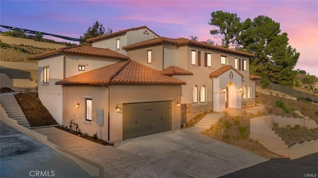 20487 Gartel Dr, Walnut, CA 91789 - mediterranean / spanish house featuring concrete driveway, an attached garage, a tiled roof, stairway, and stucco siding