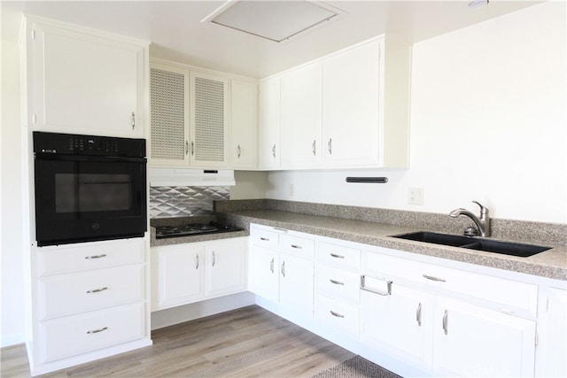 kitchen featuring light wood-type flooring, sink, white cabinetry, and black appliances