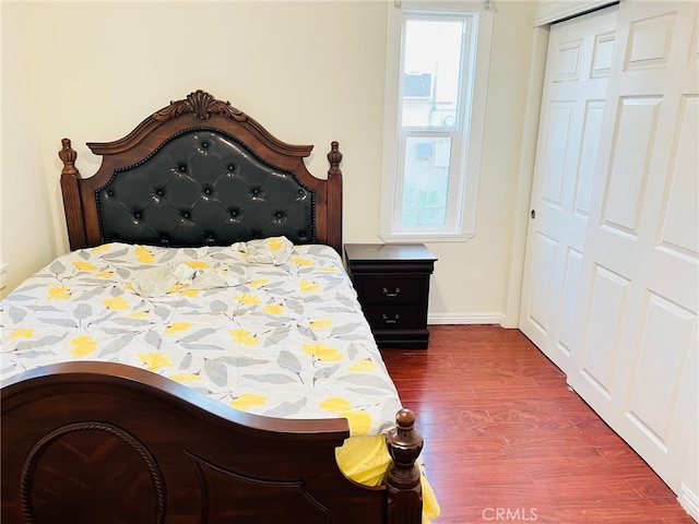 bedroom with a closet and dark wood-type flooring