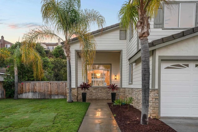 view of front of home with a garage and a lawn