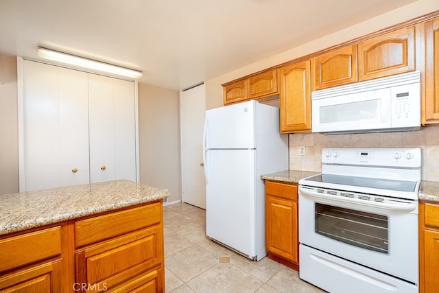 kitchen with backsplash, white appliances, light stone countertops, and light tile patterned floors