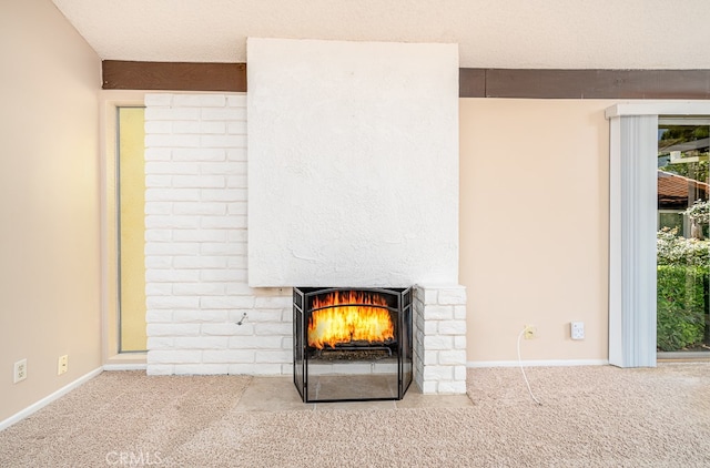 interior details featuring a textured ceiling, carpet floors, and a fireplace