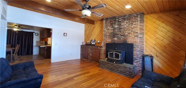 living room featuring ceiling fan, wooden ceiling, wooden walls, and light hardwood / wood-style flooring