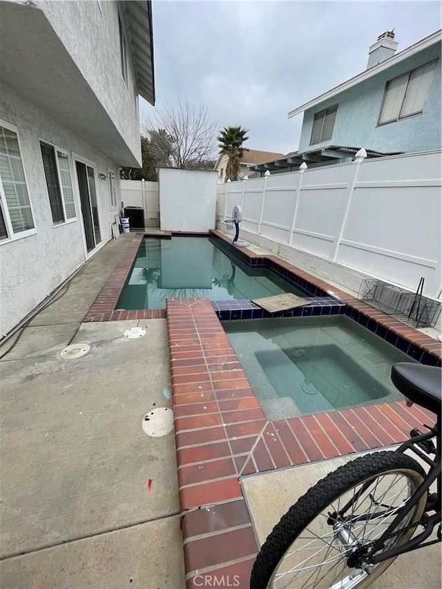 view of pool with an in ground hot tub