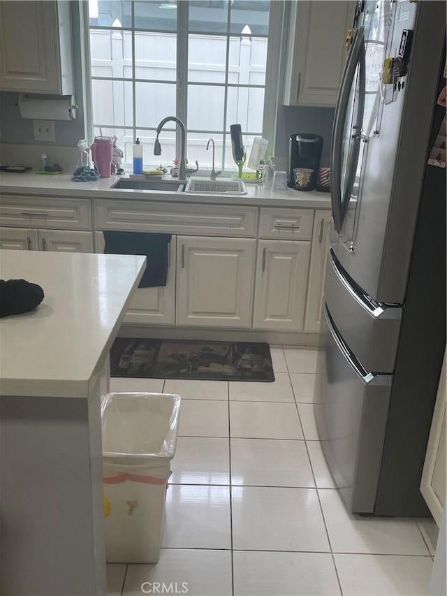 kitchen with sink, light tile patterned floors, and stainless steel refrigerator