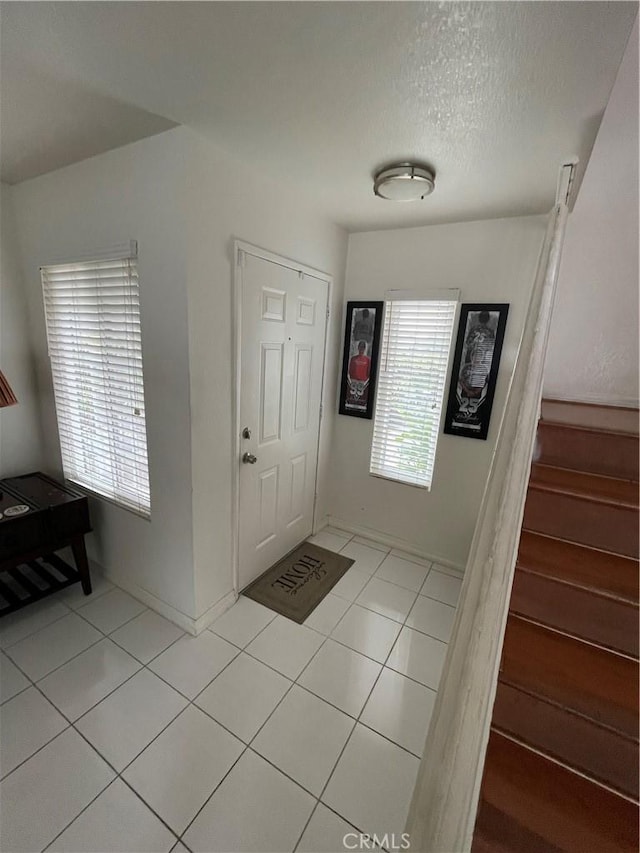 tiled entryway with a textured ceiling and a wealth of natural light