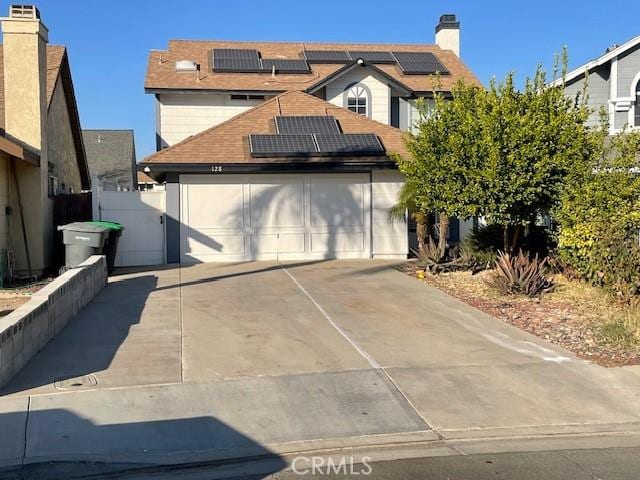 front of property with a garage and solar panels