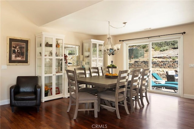 dining room featuring dark hardwood / wood-style floors, a chandelier, and vaulted ceiling