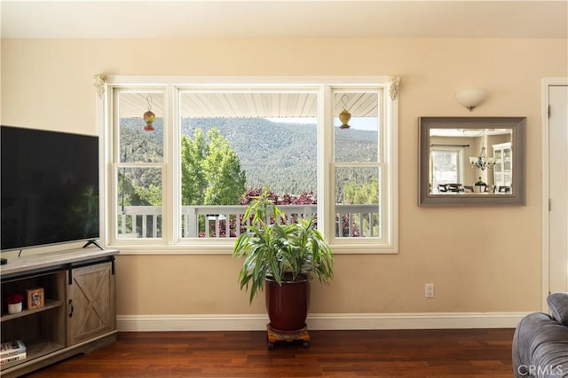 living room featuring dark hardwood / wood-style floors, a mountain view, and a notable chandelier