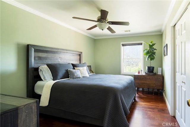 bedroom with ceiling fan, a closet, dark wood-type flooring, and ornamental molding