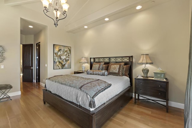 bedroom with light hardwood / wood-style flooring, a chandelier, and vaulted ceiling