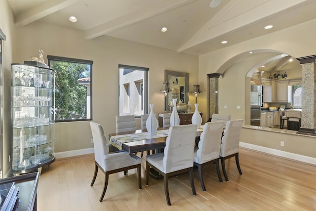 dining space with lofted ceiling with beams and light hardwood / wood-style flooring