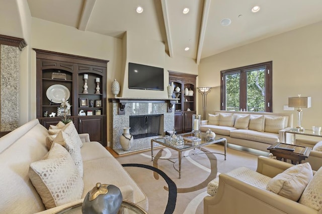 living room featuring lofted ceiling with beams and a premium fireplace