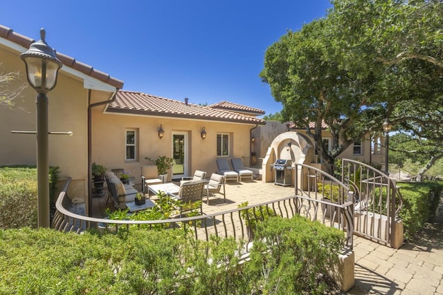 back of house featuring an outdoor living space and a patio