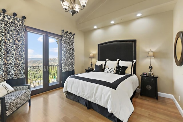 bedroom with wood-type flooring, a chandelier, vaulted ceiling, a mountain view, and access to exterior