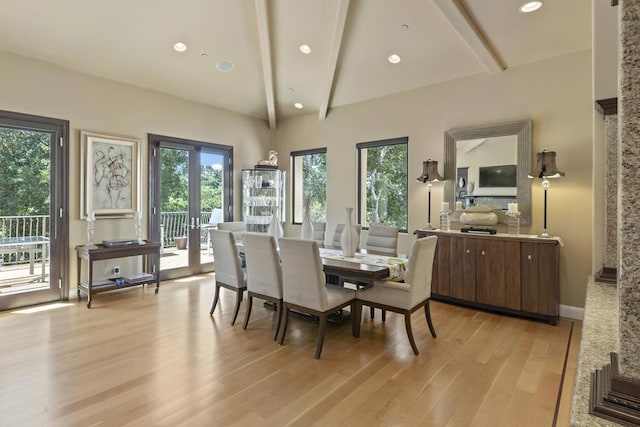 dining space featuring vaulted ceiling with beams and light hardwood / wood-style floors