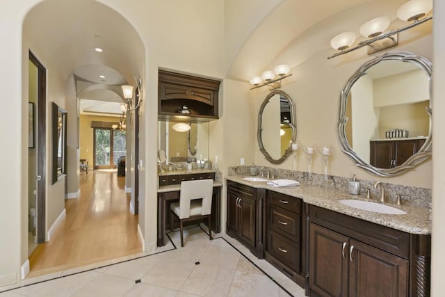 bathroom with tile patterned flooring, vanity, and an inviting chandelier