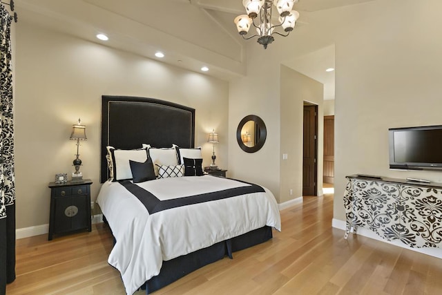 bedroom featuring high vaulted ceiling, a chandelier, and light hardwood / wood-style flooring