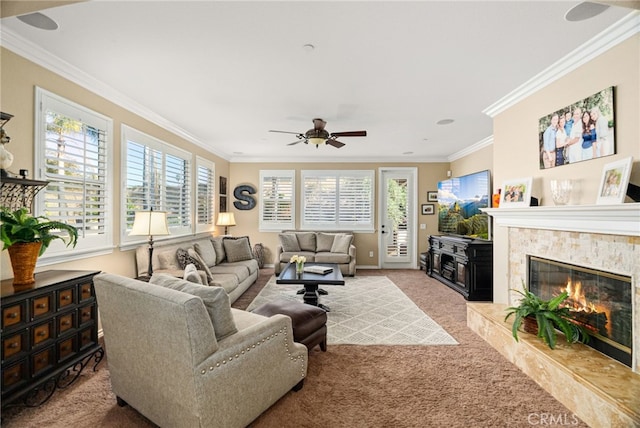 living room featuring carpet flooring, a healthy amount of sunlight, ornamental molding, and a premium fireplace