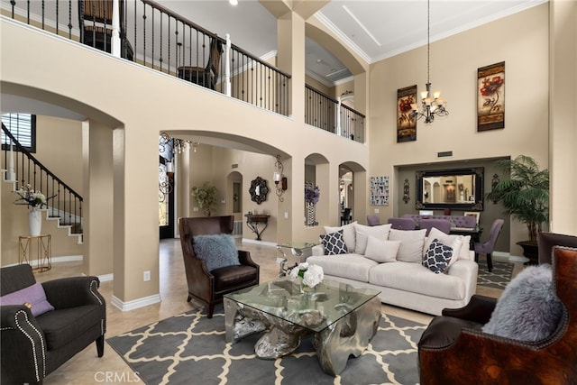 living room featuring an inviting chandelier, crown molding, and a high ceiling