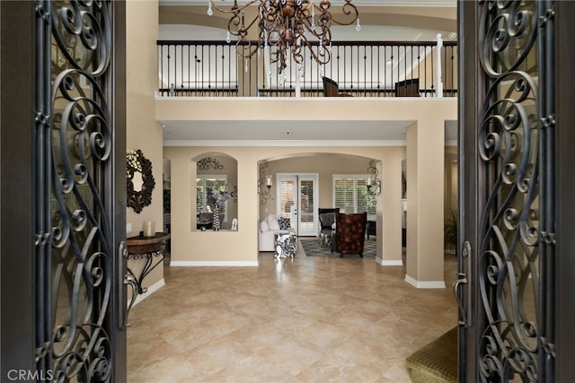 entrance foyer with crown molding and a chandelier