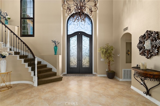 entrance foyer featuring french doors and a high ceiling