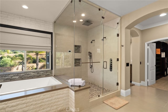 bathroom featuring independent shower and bath, ornamental molding, and tile patterned flooring