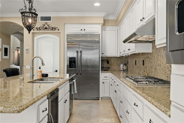 kitchen featuring a center island with sink, hanging light fixtures, light stone countertops, sink, and stainless steel appliances