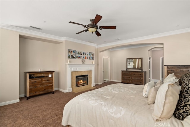 bedroom with ornamental molding, carpet flooring, a fireplace, and ceiling fan