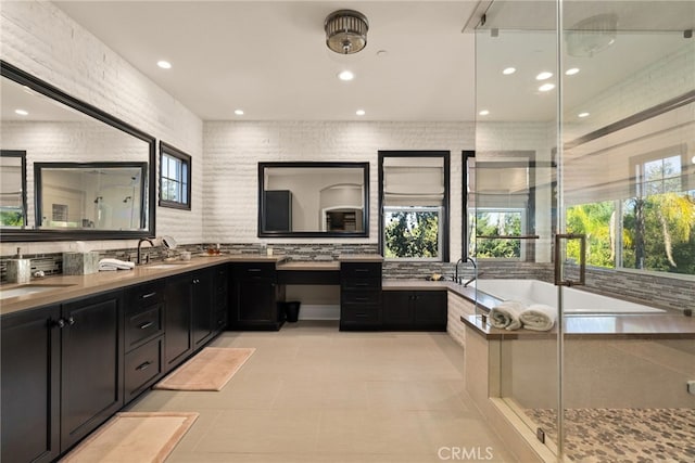 bathroom with vanity, shower with separate bathtub, tasteful backsplash, and tile patterned floors